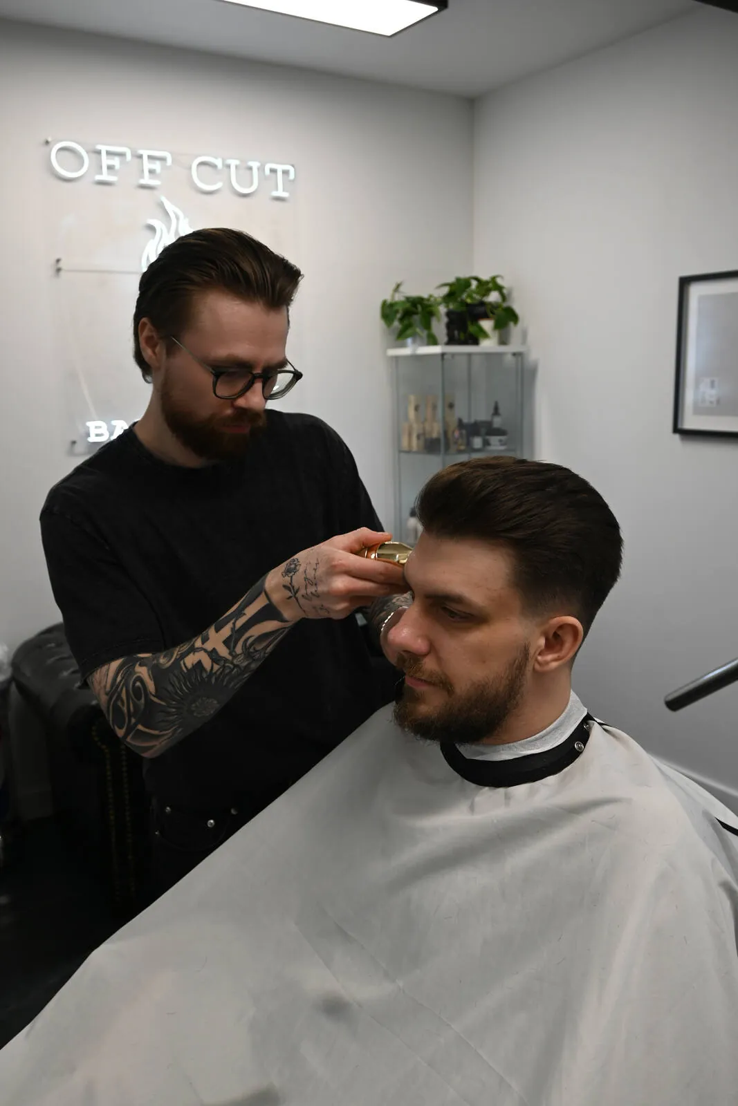 Barber strzyże i konsultuje fryzurę klienta w OFF CUT Barbershop w Szczecinie